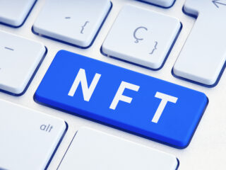 NFT or Non Fungible Token text on blue computer Keyboard Key